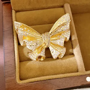 Detailed macro shot of an 18k gold plated butterfly brooch with sparkling crystals