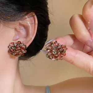 Close-up of vibrant glass beaded flower stud earrings on an Asian model's ear