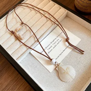 Elegant handmade white shell pendant necklace with brown cord for beach vacation style