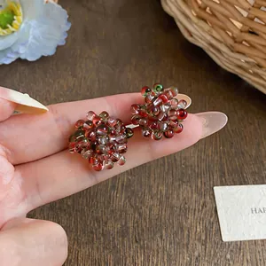 Detail view of handmade glass beaded flower stud earrings with berry-like cluster design