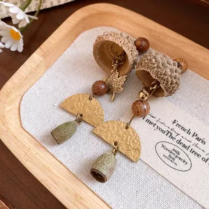 Detailed view of retro forest-style eucalyptus fruit earrings with wooden beads