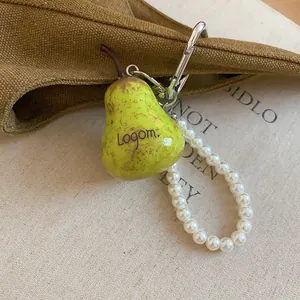 Detail of a yellow-green pear-shaped charm with a white pearl beaded loop strap