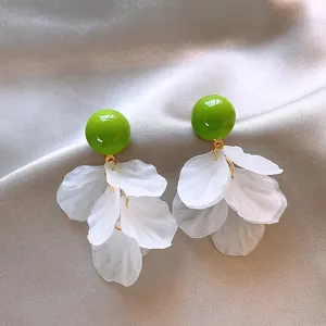 Dettaglio squisito di nappe di petali di fiori in acrilico bianco e borchie verdi
