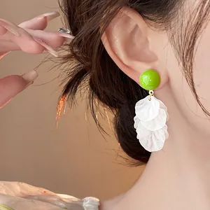 Primo piano dettagliato di eleganti orecchini a nappa con petali in acrilico verde e bianco