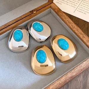 Detailed view of vintage-style oval resin earrings in gold and silver tones.