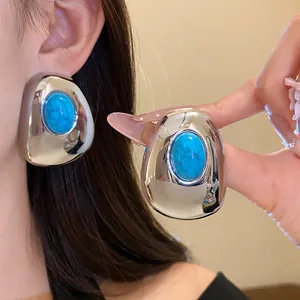 Detailed shot of vintage silver-tone oval stud earrings with turquoise resin stone