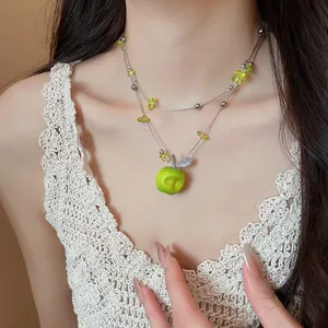 Close-up of a model wearing a double-layered green apple beaded pendant necklace.