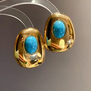 Close-up detail of vintage gold oval stud earrings with turquoise resin inlay stones