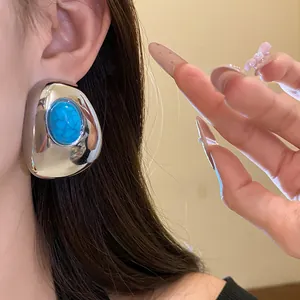 Detailed view of a vintage silver-toned chunky stud earring with a blue oval resin stone