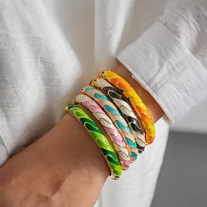 Primer plano de brazaletes de esmalte de colores estilo dopamina con patrones de ondas doradas