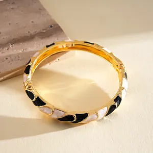 Primer plano de un brazalete de esmalte dorado con patrón jaspeado.