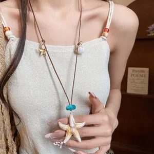 Detailed close-up of a resort-style starfish and shell pendant necklace on a model