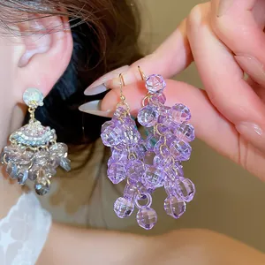 Gros plan de boucles d'oreilles en grappe de perles violettes avec texture étincelante