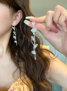 Detailed view of elegant long tassel earrings with sparkling flowers and rhinestones