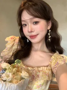 Macro view of long flower tassel earrings worn by model for elegant summer style