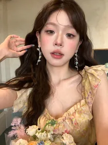 Elegant close-up of a model wearing sparkling flower long tassel drop earrings