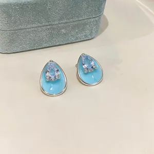 Detailed macro view of light blue enamel waterdrop earrings featuring sparkling pear-cut zircon