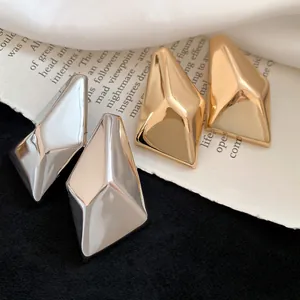 Nahaufnahme von retro unregelmäßigen geometrischen Ohrsteckern mit hochglänzendem Finish