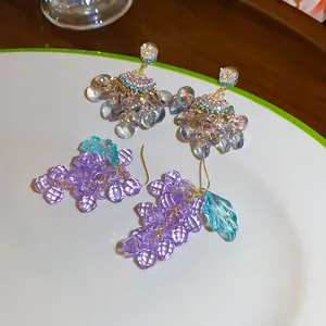 Gros plan de boucles d'oreilles en perles en forme de raisin et d'éventail