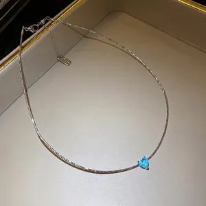 Elegant silver clavicle necklace featuring a vibrant blue heart-shaped pendant