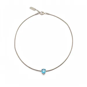 Minimalist wire cable necklace with a pear-shaped blue gemstone pendant on white background