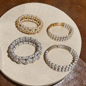 Eleganti bracciali di perle multistrato con strass in finiture oro e argento.