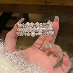Dettaglio del bracciale multistrato con perle e strass in stile lusso retrò elegante