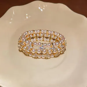 Primo piano di un bracciale di perle retrò a più strati con fiori di strass scintillanti