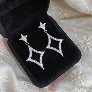 Detailed macro view of sparkling zirconia star earrings displayed in a black velvet jewelry box