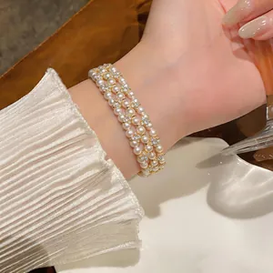 Elegante bracciale di perle multistrato con dettagli in strass scintillanti sul polso