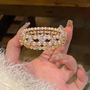Dettaglio del bracciale di perle di lusso multistrato con motivi a stella in strass oro