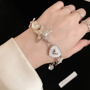 Silver star and heart charm bracelet with sparkling rhinestones worn on wrist