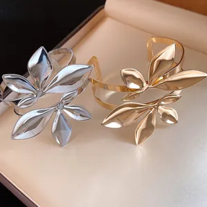 Nahaufnahme von silbernen und goldenen zweilagigen Blatt-Manschettenarmbändern in Box.