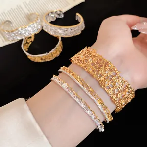 Detailed macro view of elegant gold and silver lace texture open bangles with small diamonds