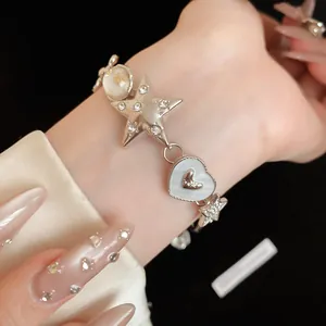 Close-up of star and heart charm bracelet with sparkling rhinestones and mother of pearl