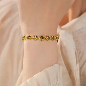 Detailed close-up of an 18k gold plated bracelet with vibrant round green zircon stones