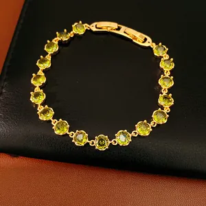 Close-up detail of an 18k gold-plated bracelet featuring round green zircon stones.