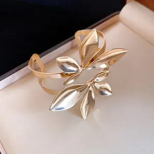 Detaillierte Nahaufnahme eines goldenen Metallarmband zweilagig mit hohlen Blattmotiven