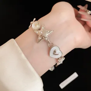 Detailed view of a silver star and heart charm bracelet featuring sparkling crystals