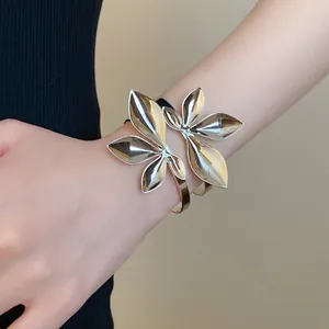 Detail eines silbernen offenen Armreifs mit Blattmuster am Handgelenk, schicker Schmuck