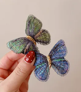 Detailed macro view of vintage knitted butterfly hair clips featuring intricate embroidery