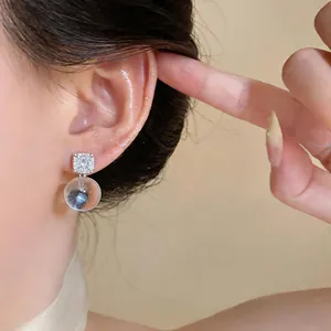 Macro detail of French style silver stud earring with rhinestone and resin ball