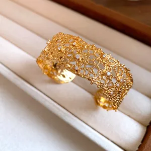 Detailed macro view of golden lace texture cuff bracelet with elegant embedded crystals