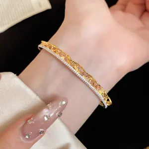 Close-up detail of a lace-textured gold and silver bangle adorned with sparkling crystals