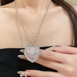 Close-up of pink enamel heart necklace with cat-eye stone on stainless steel chain