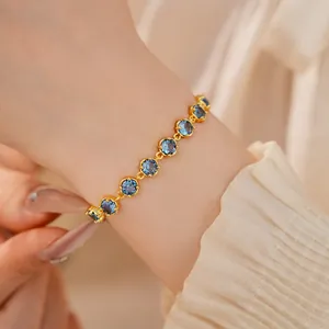Close-up of 18k gold plated bracelet with sparkling round blue cubic zirconia stones