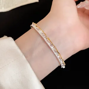 Close-up of a French lace texture pavé open bangle in two-tone silver and gold.
