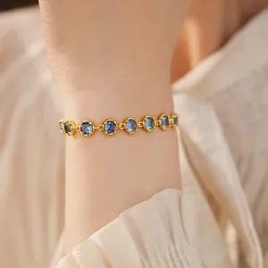 Elegant 18k gold plated bracelet featuring round blue zircon stones on a female wrist