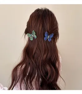 Close-up of vintage knitted butterfly hair clips in green and blue on wavy hair