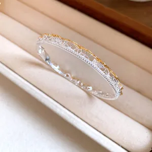 Detail showing intricate lace texture and pave-set crystals on a silver bangle